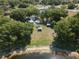 Aerial view of lakefront property featuring lush greenery, picnic shelters, and tranquil waterfront at 22304 Stillwood Dr, Land O Lakes, FL 34639