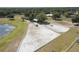 Aerial view of horse property with equestrian facilities and pond surrounded by lush trees at 22304 Stillwood Dr, Land O Lakes, FL 34639