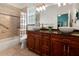 Bathroom featuring double sinks with a marble countertop, tiled shower, and large vanity at 22304 Stillwood Dr, Land O Lakes, FL 34639