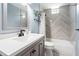 Updated bathroom featuring gray-toned walls, stone tile floors and patterned tile accent wall in the shower/tub combo at 22304 Stillwood Dr, Land O Lakes, FL 34639