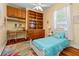 Cozy bedroom featuring wood floors, built in shelves, and a well-lit study area at 22304 Stillwood Dr, Land O Lakes, FL 34639