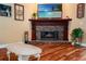 Living room with hardwood floors, fireplace with flatscreen television, and a light-colored coffee table at 22304 Stillwood Dr, Land O Lakes, FL 34639