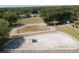 Aerial view of a large horse arena with white fencing in a green, wooded community at 22304 Stillwood Dr, Land O Lakes, FL 34639