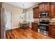 Kitchen with dark brown cabinetry, stainless steel appliances, and small breakfast nook with bright blue chairs at 22304 Stillwood Dr, Land O Lakes, FL 34639