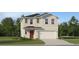 Charming two-story home with neutral siding, a red front door, and an attached two-car garage at 2277 Blue Grosbeak Pl, Wimauma, FL 33598
