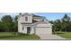 Charming two-story home features a two-car garage, neutral paint, a landscaped yard and architectural shingles at 2283 Blue Grosbeak Pl, Wimauma, FL 33598