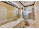 Well-lit bathroom with granite countertop, a shower-tub combination, and decorative accents at 2300 Hannah S Way, Dunedin, FL 34698