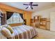 Comfortable bedroom with a ceiling fan, built-in desk and shelving, and a bright window at 2300 Hannah S Way, Dunedin, FL 34698