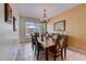 Dining room with wooden table, six chairs, chandelier, and natural light at 2300 Hannah S Way, Dunedin, FL 34698
