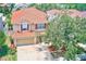 Charming two-story home with a red tile roof, beige siding and well-manicured landscaping at 2300 Hannah S Way, Dunedin, FL 34698