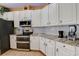 Bright kitchen with stainless steel appliances, stone countertops, and white cabinets at 2300 Hannah S Way, Dunedin, FL 34698