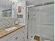 Bathroom with marble countertops and tiled shower with glass doors at 2331 Belleair Rd # 214, Clearwater, FL 33764