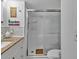Bathroom with marble countertops and tiled shower with glass door at 2331 Belleair Rd # 214, Clearwater, FL 33764