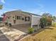 Inviting home exterior with a carport, an American flag, green shutters, and mature landscaping at 2331 Belleair Rd # 214, Clearwater, FL 33764