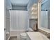 Well-lit bathroom with a shower-tub, white vanity, and practical storage shelves at 2510 Cross More St, Valrico, FL 33594