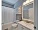 Cozy bathroom with white fixtures, a shower-tub combination, and a large mirror at 2510 Cross More St, Valrico, FL 33594