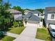 Aerial view of a well-maintained home showcasing lush landscaping, a two-car garage, and a concrete driveway at 2510 Cross More St, Valrico, FL 33594