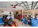 Spacious garage with ample storage, featuring an orange motorcycle, tools, overhead lighting, and an automatic garage door opener at 2510 Cross More St, Valrico, FL 33594