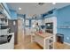 Charming kitchen with vibrant blue walls, white cabinetry, an island, and modern stainless steel appliances at 2510 Cross More St, Valrico, FL 33594