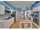 Well-lit kitchen with blue walls, white cabinets, stainless steel appliances, and a convenient island at 2510 Cross More St, Valrico, FL 33594