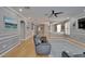 Open-concept living room boasts elegant gray walls, hardwood floors, and comfortable seating with a ceiling fan at 2510 Cross More St, Valrico, FL 33594