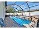 Sparkling pool in a screened enclosure with a waterfall feature and ample patio space at 2510 Cross More St, Valrico, FL 33594
