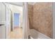 Well-lit bathroom with tiled shower, tiled floors, and hallway with closet at 2706 Bent Leaf Dr, Valrico, FL 33594