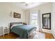 Cozy bedroom with a queen-sized bed, wood floors, and natural light from the window at 2706 Bent Leaf Dr, Valrico, FL 33594