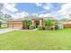 Inviting single-story home featuring a well-manicured lawn, mature landscaping, and a two-car garage at 2706 Bent Leaf Dr, Valrico, FL 33594