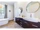 Elegant bathroom with dual vanities, stylish mirrors and a luxurious soaking tub by the window at 2706 Bent Leaf Dr, Valrico, FL 33594