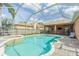 Backyard with a screened pool, spa, and seating area, perfect for outdoor relaxation and entertaining at 2706 Bent Leaf Dr, Valrico, FL 33594