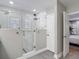Modern bathroom featuring a glass-enclosed shower with a tiled floor and a view into an adjacent bedroom at 2874 Bayshore Trails Dr, Tampa, FL 33611