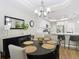 An open dining room featuring a chandelier, wood floors, and kitchen access at 2874 Bayshore Trails Dr, Tampa, FL 33611