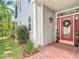 A charming front entrance with a red door, brick walkway, and decorative shrubbery at 2874 Bayshore Trails Dr, Tampa, FL 33611