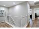 Upstairs hallway with wood floors, white railing and access to other rooms in the home at 2874 Bayshore Trails Dr, Tampa, FL 33611