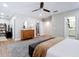 Spacious main bedroom features wood-look flooring, ceiling fan, walk-in closet, ensuite bathroom, and decorative dresser at 2874 Bayshore Trails Dr, Tampa, FL 33611