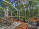 Outdoor patio with lounge and dining seating within a screened enclosure surrounded by landscaping at 2874 Bayshore Trails Dr, Tampa, FL 33611