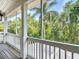 Inviting screened porch with wood floors and railing offers serene views of lush greenery at 2874 Bayshore Trails Dr, Tampa, FL 33611