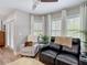 Brightly lit sitting area features plantation shutters, comfortable seating and wood-look flooring at 2874 Bayshore Trails Dr, Tampa, FL 33611