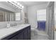 Elegant bathroom featuring a marble countertop, classic blue cabinets, and neutral-toned walls and fixtures at 3109 Tarpon Woods Blvd, Palm Harbor, FL 34685