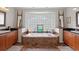 Bright bathroom with a soaking tub and tiled surround, dual vanities, and decorative accents at 3109 Tarpon Woods Blvd, Palm Harbor, FL 34685
