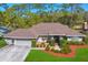 Well-maintained single-story home featuring a two-car garage and landscaped front yard at 3109 Tarpon Woods Blvd, Palm Harbor, FL 34685