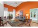 Bright living room features modern gray sofa, vaulted ceiling, and orange accent wall at 3109 Tarpon Woods Blvd, Palm Harbor, FL 34685