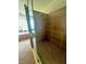 Shower stall featuring decorative tile, a shower head, and a seamless glass door at 3109 Tarpon Woods Blvd, Palm Harbor, FL 34685
