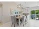 Elegant dining area featuring a modern chandelier, seating for six, and sliding door views of the pool at 330 47Th N Ave, St Petersburg, FL 33703
