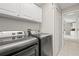 Functional laundry room with modern washer and dryer units and overhead cabinets at 330 47Th N Ave, St Petersburg, FL 33703