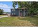 Inviting two-story home featuring a charming red door, stately columns, and a beautiful mature shade tree at 4125 89Th E St, Palmetto, FL 34221