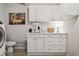 Bright laundry room features white cabinetry, sink, and plenty of counter space for folding at 4417 W Fair Oaks Ave, Tampa, FL 33611