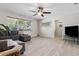 Comfortable living room featuring wood-look flooring, plush seating, and a large window at 4417 W Fair Oaks Ave, Tampa, FL 33611