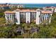 Stunning aerial view of a beachfront building with a terracotta roof and lush green landscaping at 4750 Dolphin Cay S Ln # 209, St Petersburg, FL 33711